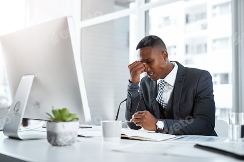 Stressed Man at Desk in Bright Office