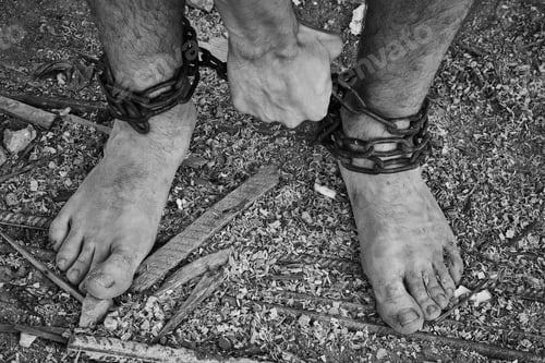 Preview: Close-up shot of barefoot legs tied up with old chain