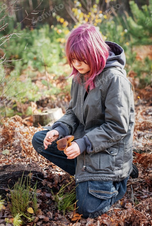 Preview: Teenager finding mushrooms in autumn forest outdoors