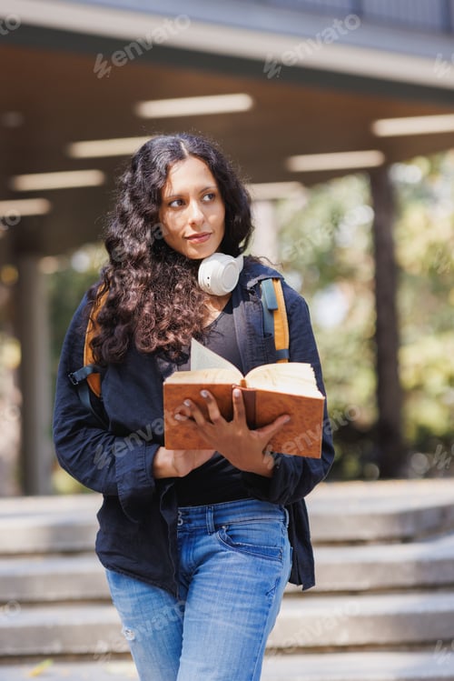 Preview: Young woman studying book on university campus