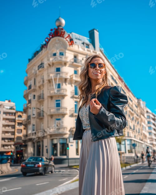Preview: Gorgeous young blond Caucasian woman in an evening dress and a black leather jacket