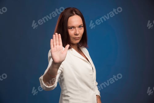 Preview: Young businesswoman in white blazer saying goodbye