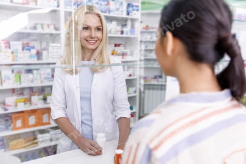 Preview: pharmacist and customer looking at each other in drugstore