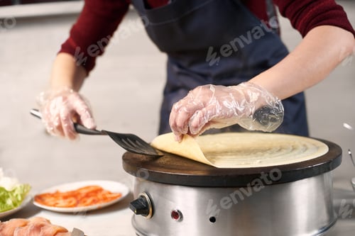 Preview: Chef hands turn over pancake by spatula on portable cooktop. Baking process.