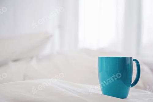 Preview: A Blue Mug Sits on a White Bed
