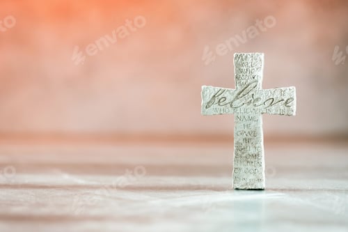 Preview: Stone cross with inscription Believe on grey background, Copy space. Christian backdrop. Biblical