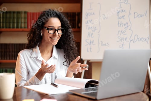 Preview: English teacher sitting at desk, explaining lesson to students