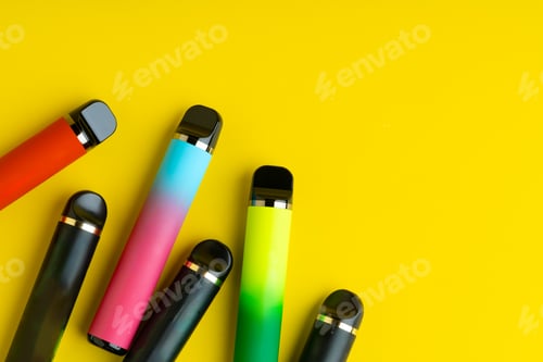 Preview: Colorful disposable electronic cigarettes on yellow background