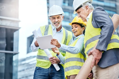 Preview: Shot of a group of businesspeople using a digital tablet while working at a construction site