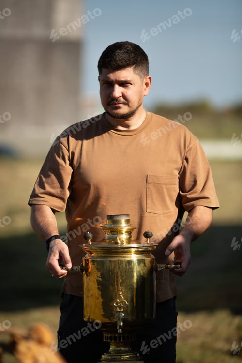 Preview: A man holds a samovar in his hands