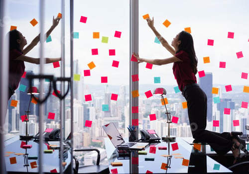 Preview: Busy Person Attaching Many Sticky Notes On Large Window