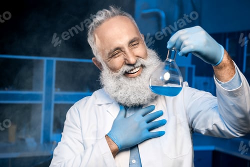 Preview: happy mature scientist in lab coat holding flask with reagent at laboratory