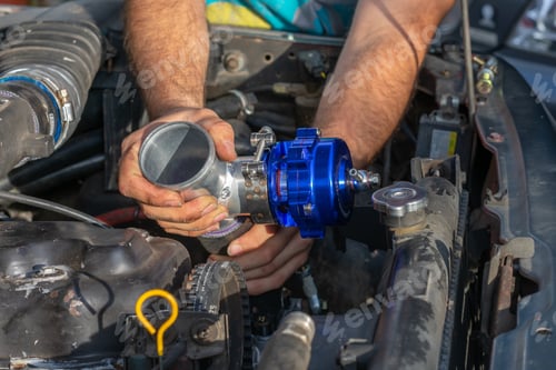 Preview: Hands of car mechanic with wrench in garage, selective focus