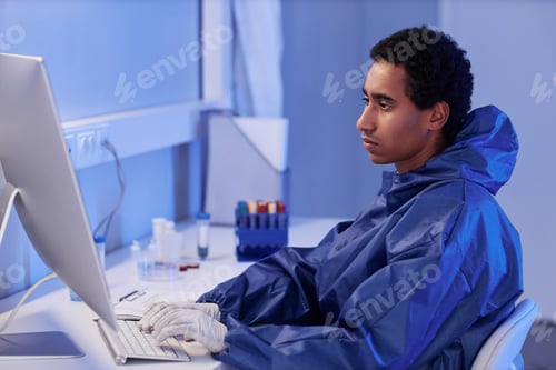 Preview: Side view young male scientist using computer in laboratory