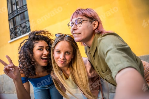 Preview: Women gesturing success while taking selfie together