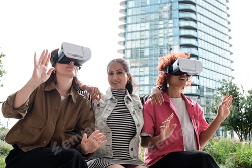 Preview: Three young women experiencing virtual reality with headsets outdoors