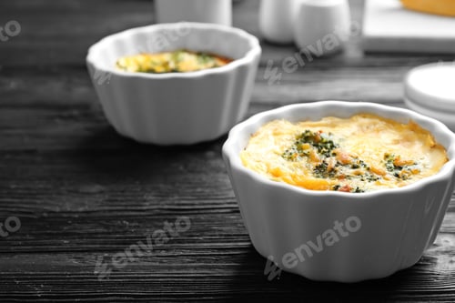 Preview: Tasty broccoli casserole in ramekins on black wooden table