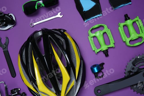 Preview: Set of different bicycle tools, accessories and parts on purple background, flat lay