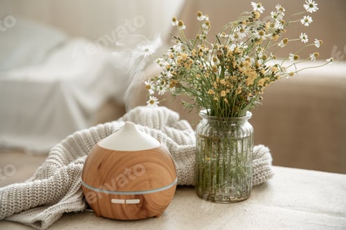 Preview: Cozy home composition with an air humidifier and wildflowers in a vase.