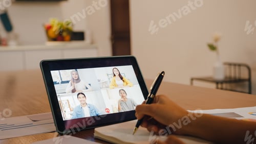 Preview: Asia businesswoman using digital tablet talk to colleague by video call at home.