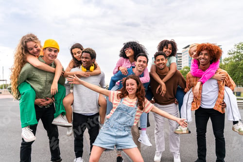 Preview: Happy playful multiethnic group of young friends bonding outdoors