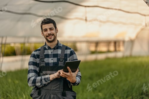Preview: Farmer using digital tablet in greenhouse: monitoring and managing crops with technology