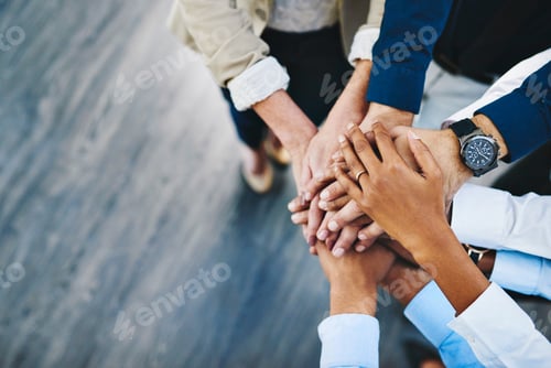 Preview: Shot of a group of unrecognisable businesspeople joining their hands together in unity in an office