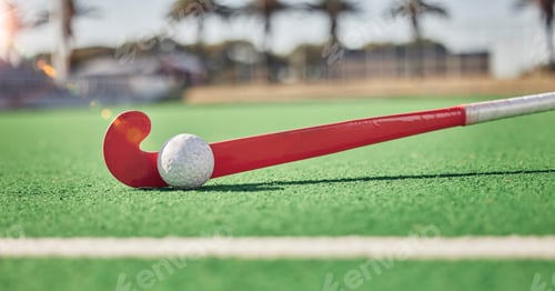 Preview: Closeup, hockey and hockey stick with ball on field in sunshine for sport, contest or competition i