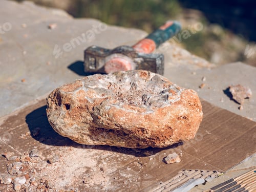 Preview: Piece of stone on table near hammer