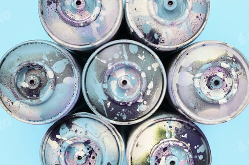 Preview: A few used spray cans with blue paint drips lie on texture background of fashion pastel