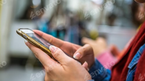 Preview: Asian woman sit down in metro and holds smartphone. Passenger using phone