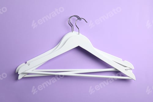 Preview: Flat lay composition with empty hangers on color background