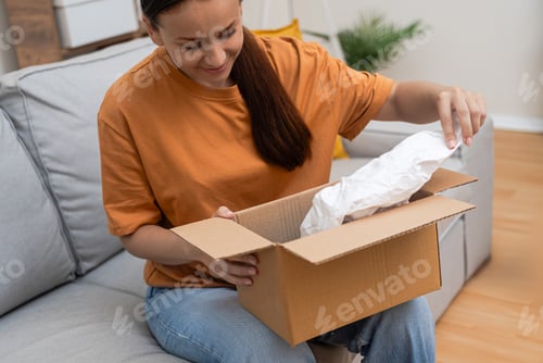 Preview: With excitement, shopaholic woman inspects parcel, e-commerce and express online shopping