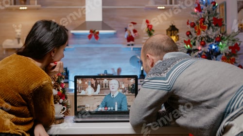 Preview: Couple using video call conference with father on christmas eve