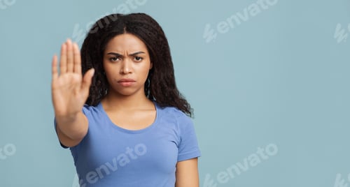 Preview: No discrimination. African american woman showing stop gesture to camera over blue background