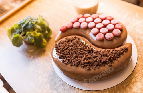 Visualização: Em uma velha mesa de madeira, há um lindo bolo de chocolate, uma xícara transparente com café e um