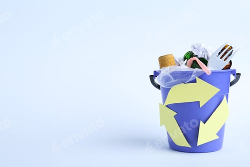 Preview: Bucket with recycling symbol full of garbage on white background. Space for text