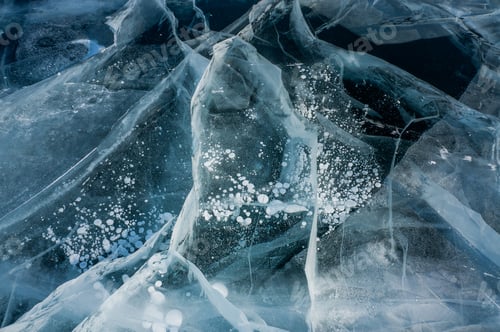 Preview: close up view of cracks of frozen water in winter