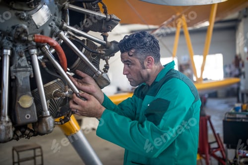 Preview: Mechanic in hangar repairing light aircraft