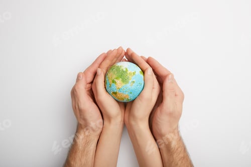 Preview: top view of man and woman holding planet model on grey background, earth day concept
