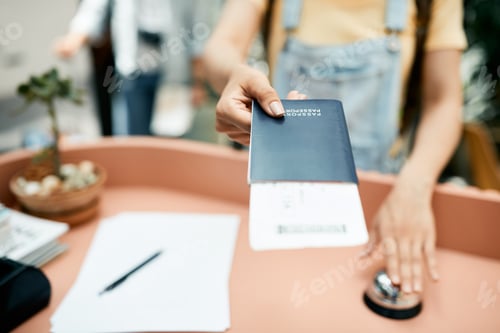 Preview: Close-up of tourist giving her passport while checking in at hotel reception.