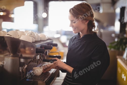 Preview: Smiling young waitress using espresso maker