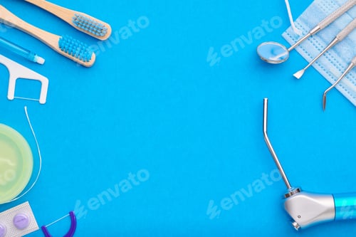 Preview: Dentist tools over blue background top view