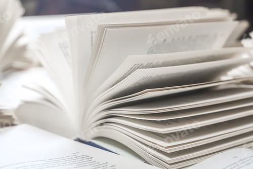 Preview: stack of books, close up. Open book on the table in library.