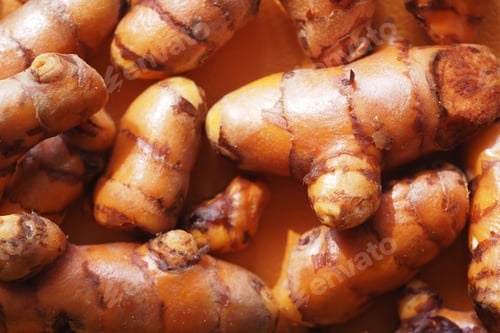 Preview: Fresh turmeric root displayed in natural light on a wooden surface