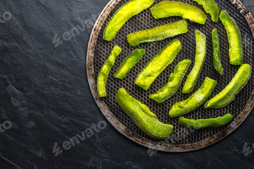 Preview: Bright green pieces of pomelo on the grill and on the blue stone free space