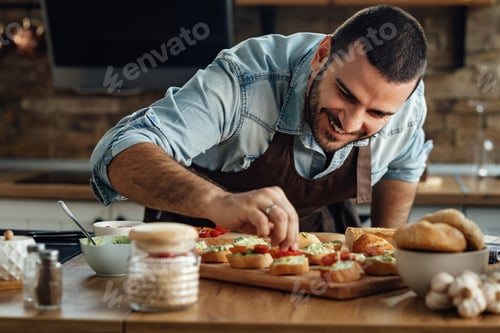 Preview: Happy man enjoying in preparing a healthy appetizer in the kitchen.