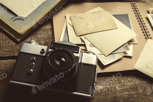 Preview: Vintage camera and old photographs on wooden table with albums and blank cards