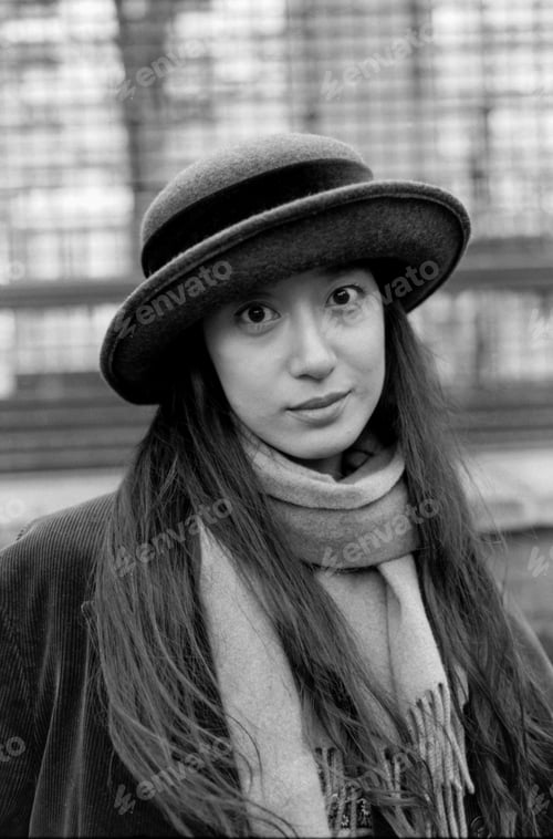 Preview: Young woman wearing hat and scarf posing in monochrome analog portrait
