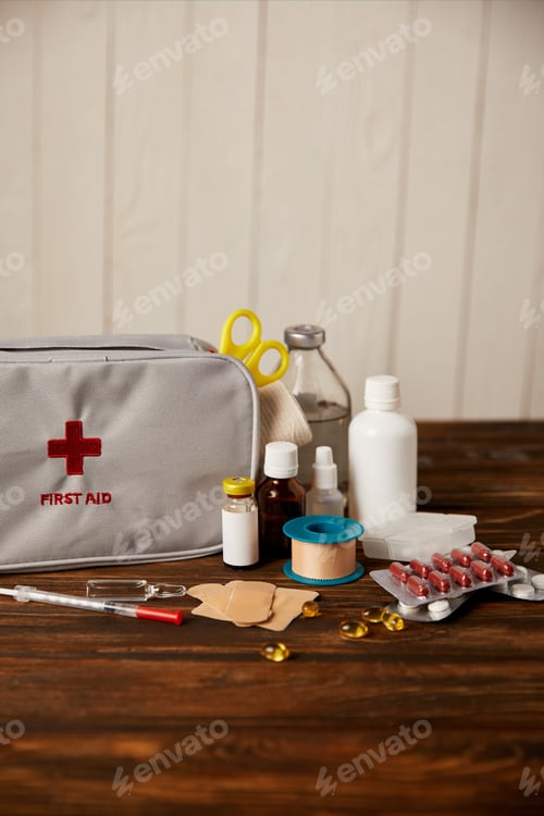 Preview: close-up shot of first aid kit with different medicines on wooden tabletop